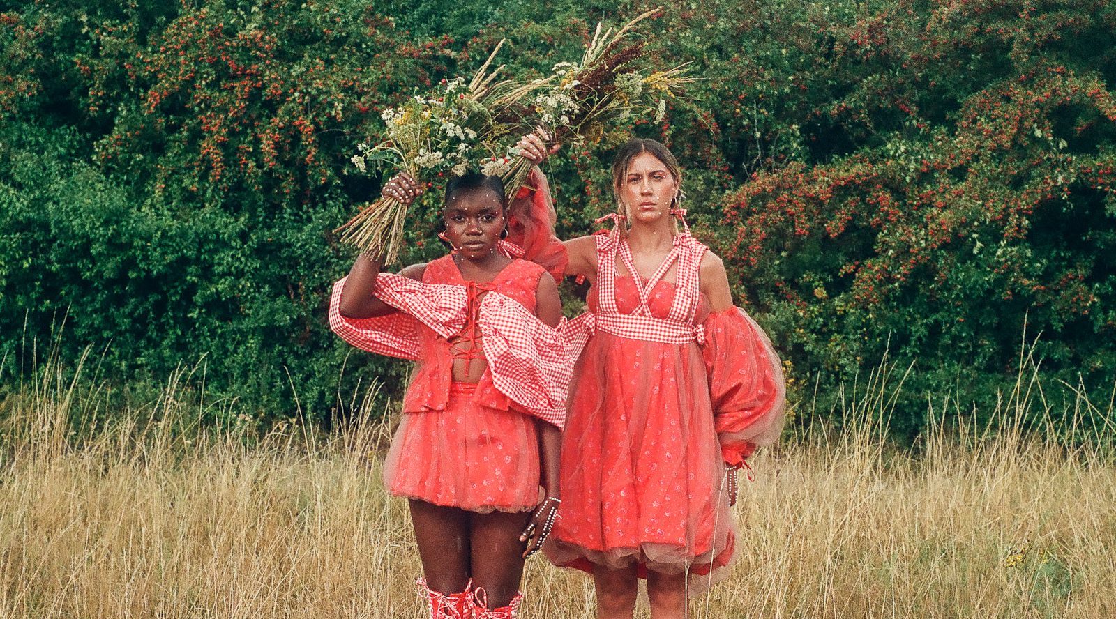 Fotografía analógica en la que se retrata a dos mujeres vestidas de rojo en un entorno natural